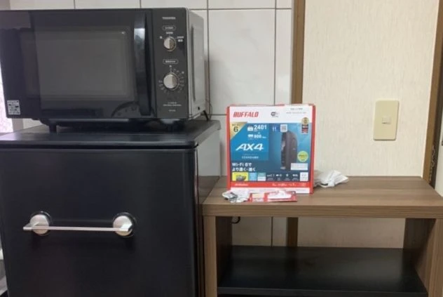 リゾートバイトのシェアタイプ個室寮の共用設備の画像。電子レンジと冷蔵庫が見える。