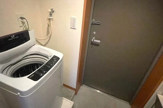 リゾートバイト寮にある洗濯機。玄関近くに設置されており、生活に便利な設備が整っている。