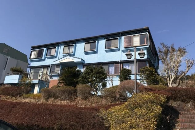 空に映える、明るい水色の寮の外観。リゾート地での生活を快適に過ごせます。