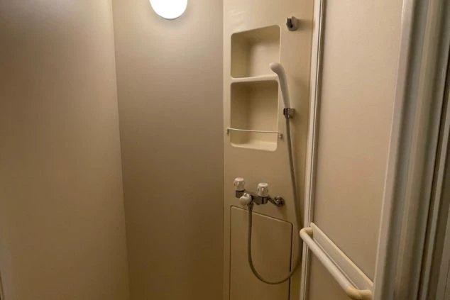 ベージュの壁に取り付けられた白い洗面器具