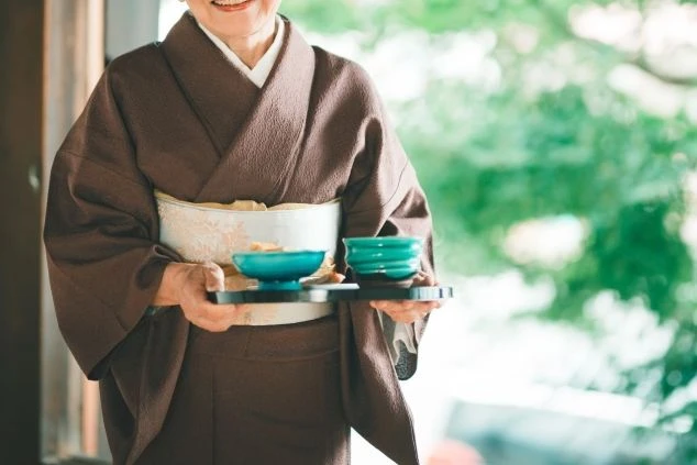 お茶を運ぶ着物姿のスタッフ。旅館でのリゾートバイトは、日本の伝統的なおもてなしを学べるチャンスです。
