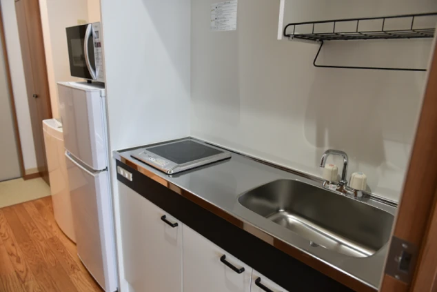 静岡県下田でのリゾートバイトの寮のキッチンの画像。一口IHコンロがあり、電子レンジや冷蔵庫も完備。