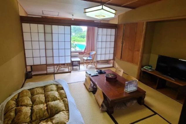 窓の外にプールが見える広々とした寮の部屋。畳敷きで落ち着ける空間で、ゆったりとリフレッシュできます。