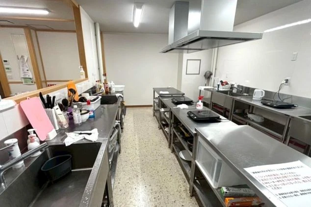 リゾートバイトの寮に備え付けられた喫煙所の画像。屋根のあるスペースに灰皿が置かれており、喫煙者が利用できる。リゾートバイトの寮の共用スペースの画像。