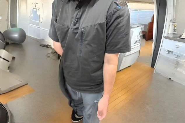 黒いポロシャツとグレーのパンツを着用した、リゾートバイトの清掃・洗い場スタッフの制服。動きやすさを重視した服装で、仕事内容をイメージさせる画像。