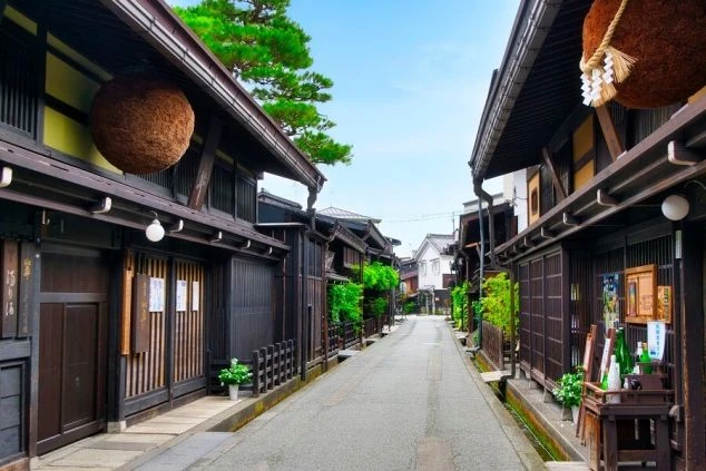 岐阜県飛騨高山（ひだたかやま）の古い街並みの風景の画像。木造の建物が立ち並ぶ通りを、リゾートバイトの休日に観光を楽しんでいる様子が伝わってくる、街の風景の画像。