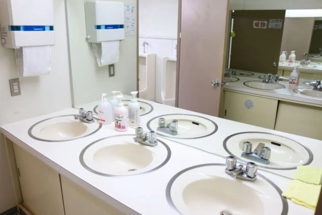 寮の男子トイレにある共用洗面所の画像。鏡に複数並んだ蛇口と手洗い石鹸がある。
