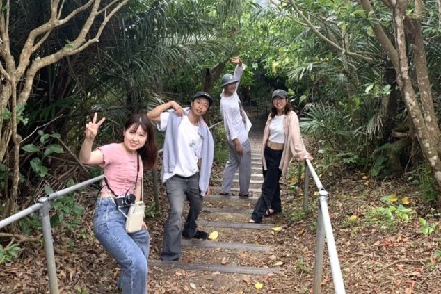 沖縄のジャングルで自然を満喫する若者たち。探検気分で森の散策を楽しむ友人グループ。ワーケーション中のアクティビティやチームビルディングに最適。