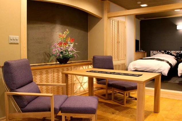 リゾートホテルや旅館の客室。モダンなベッドと和風のテーブルセットがある部屋。リゾートバイトで働く場所の雰囲気や職場のイメージ。