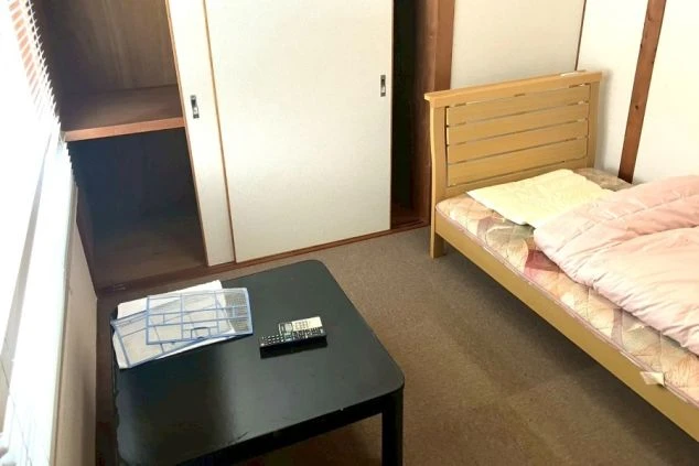 リゾートバイトの個室寮室内。ベッドやテーブル、収納が完備され、カバン一つですぐに生活を始められる環境。