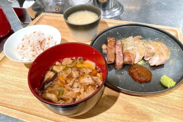 リゾートバイトのまかない画像。肉、味噌汁、雑穀米などがのったバランスの良い食事。