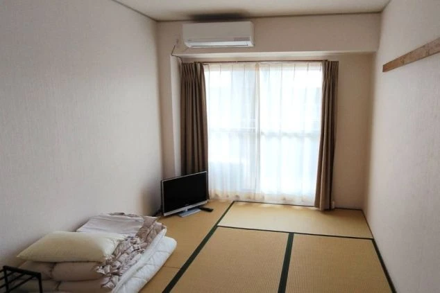 リゾートバイト先で入寮する個室寮の部屋の画像。畳の部屋でエアコン・カーテンが付属している。
