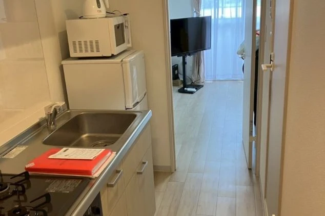 リゾートバイトの個室寮に完備されたキッチンの画像。冷蔵庫、電子レンジ、コンロ付きで自炊可能(ワンルーム寮)。