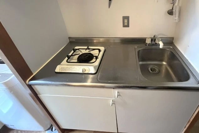 リゾートバイトの寮に完備されたキッチンの画像。ガスコンロ、シンク付きで自炊が可能。