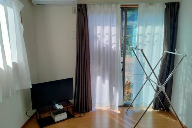リゾートバイトの寮の部屋。広々とした洋室にテレビやエアコンを完備。窓が大きく、明るい空間で生活できる。