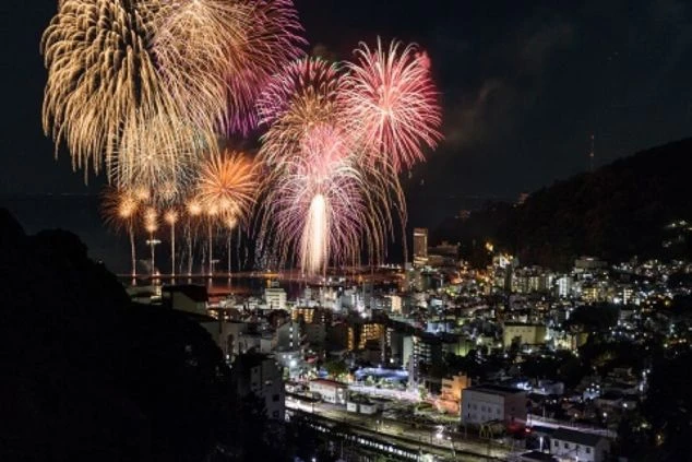  海辺の温泉街で打ち上がる花火大会。夜景を彩る美しい花火。リゾートバイトの休日に楽しめるイベントや観光スポット。