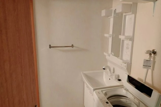 リゾートバイトの寮の独立洗面台。鏡と収納棚があり、下に洗濯機置き場が完備されている。