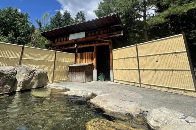 小川屋の建物正面と、道路脇に立つ「下呂温泉 小川屋 入口」の縦長看板。和風の庇と洋風の建物が組み合わさった外観。