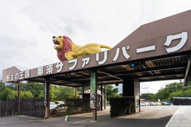 栃木県那須サファリパークの入口ゲート。「野生の王国」と書かれた看板とライオンの像。動物園やテーマパークでのリゾートバイト求人。