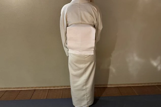 旅館の制服であるベージュ色の着物を着用した女性スタッフ