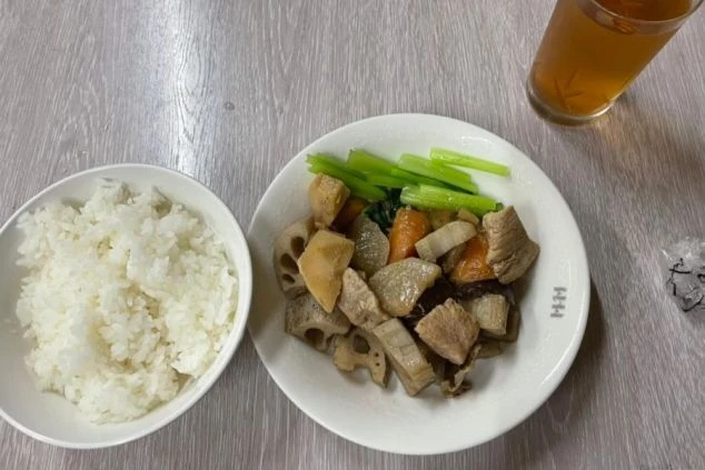 リゾートバイトのまかない画像。れんこんや大根の煮物と白米、冷たいお茶のセット。