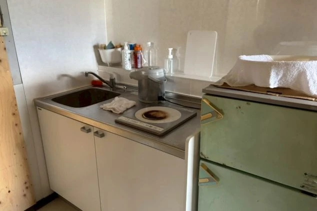 リゾートバイトの寮の共同キッチン。IHコンロ、シンク、冷蔵庫があり、自炊で食費を節約できる。