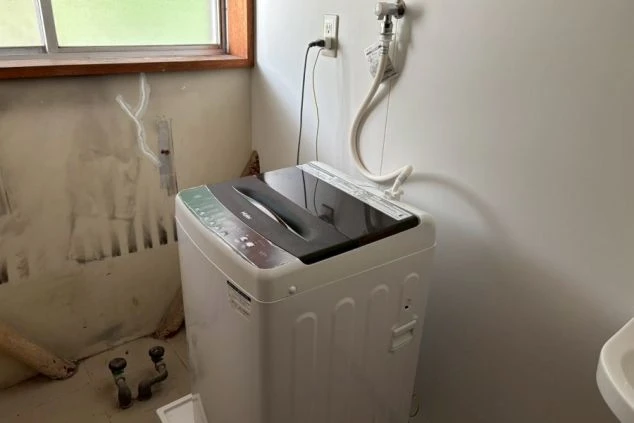 リゾートバイトの寮の洗濯機。共用スペースに設置された洗濯機で、洋服の洗濯ができる。