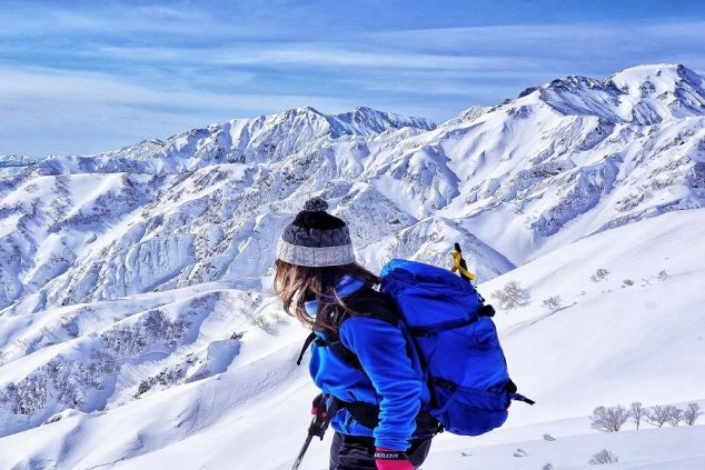 白馬の雪山でバックカントリーや登山を楽しむ女性の画像。
