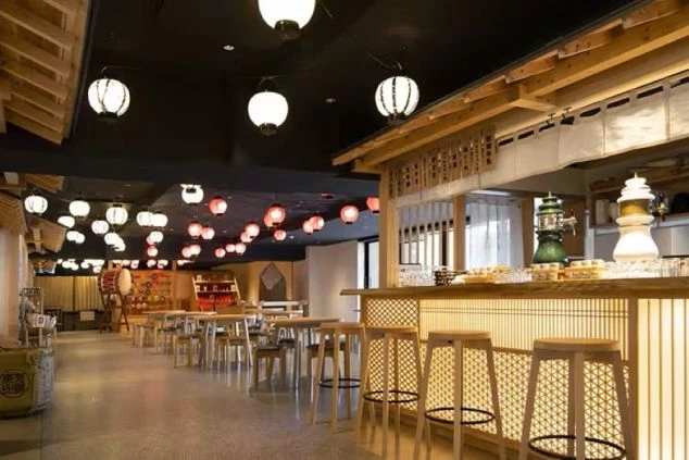 提灯や和風の照明がおしゃれな居酒屋風のレストランのダイニングの画像。木目調のカウンター席やテーブル席が並び、活気のある雰囲気が漂う。リゾートバイトの仕事内容を表す、ホテルのダイニングの画像。