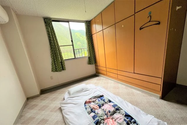 リゾートバイト寮の個室の一例。窓から自然豊かな景色が望め、壁一面の大容量な収納も完備しています。