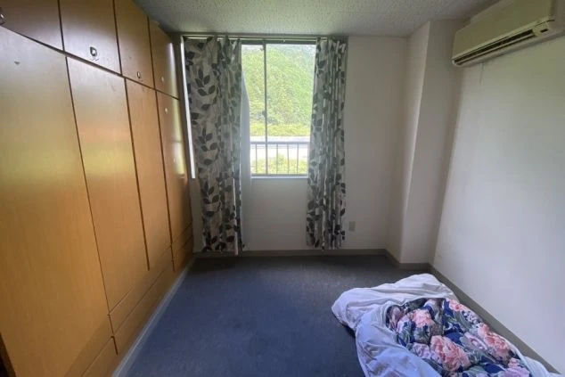 リゾートバイト寮の個室の一例。窓から自然豊かな景色が望め、壁一面の大容量な収納も完備しています。