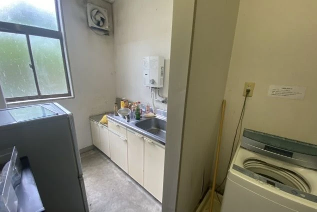 リゾートバイト寮の共同スペース。洗濯機や冷蔵庫、ミニキッチンなどが揃っており、長期滞在でも安心です。