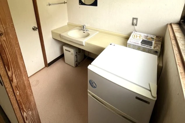 冷蔵庫や洗面台が設置された、清潔感のある共有スペース。共同生活でも安心して過ごせる環境です。