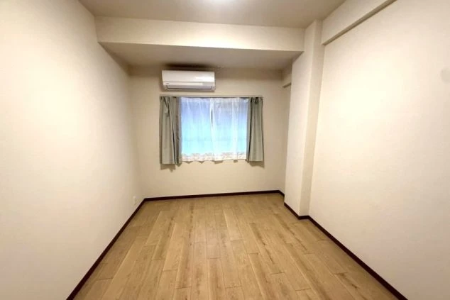 リゾートバイト完全個室寮の室内。エアコン完備の綺麗なフローリング洋室で、快適な住み込み生活が可能。