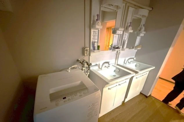 リゾートバイト寮の設備。清潔な独立洗面台と洗濯機を完備。毎日の身支度や洗濯もスムーズに行える環境。