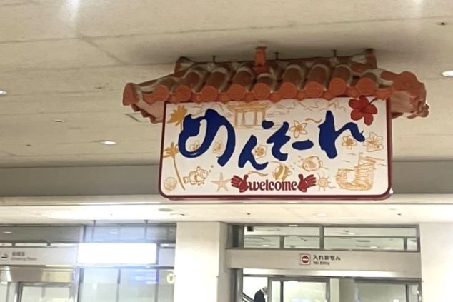 那覇空港に到着した観光客を出迎える「めんそーれ」の看板。リゾートバイトで沖縄に訪れた瞬間から、南国気分が高まります。