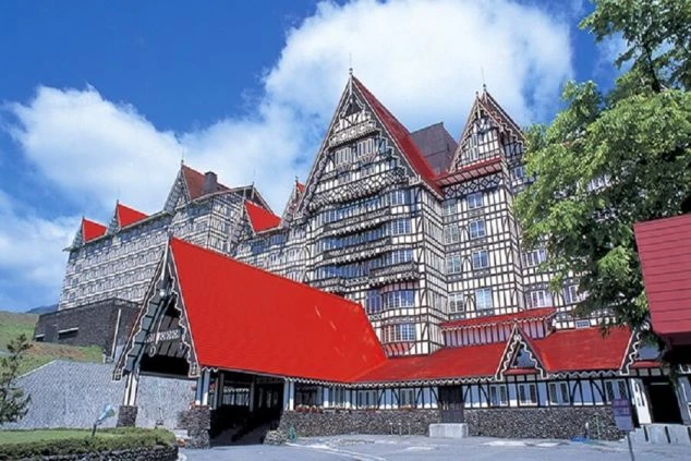 ホテルグリーンプラザ白馬の壮大な外観。赤い屋根とハーフティンバー様式の建物。白馬でのリゾートバイト求人があるスキー場ホテルのイメージ。