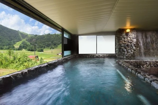 スキー場の緑が見える温泉浴場。リゾートバイトの特典として無料入浴できる温泉。仕事終わりに絶景を見ながらリラックス。
