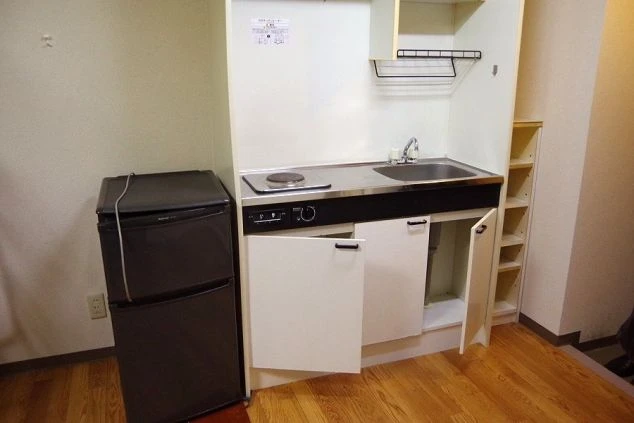 リゾートバイトの寮のミニキッチン。IHコンロ、シンク、冷蔵庫があり、自炊で食費を節約できる設備。