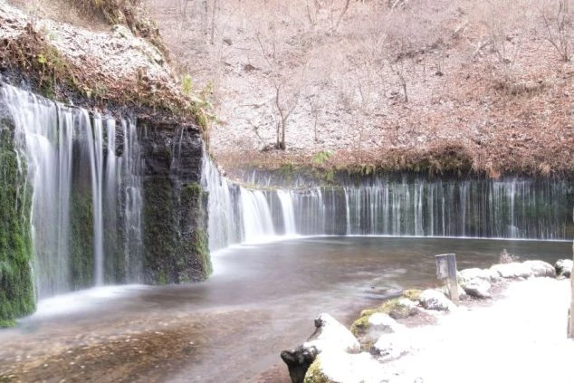 初冬に雪が積もる軽井沢の白糸の滝の画像。自然豊かな観光地でのリゾートバイトをイメージ。