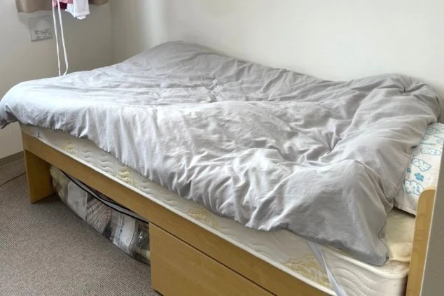 リゾートバイトの個室寮の部屋内にあるベッドの画像。ベッド下には収納がある。