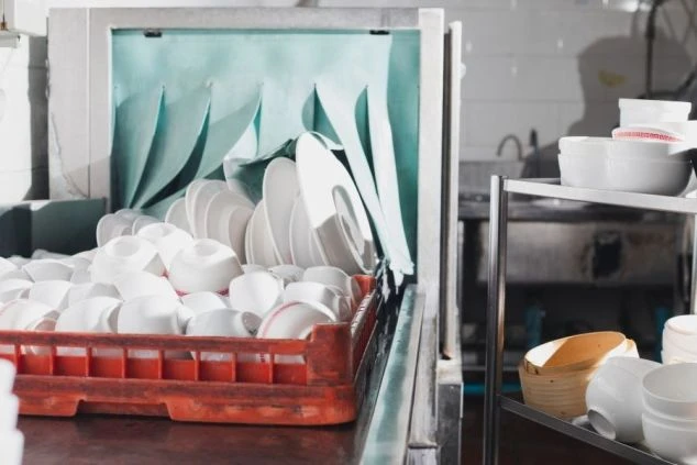 大量の食器が積まれた食洗機。洗い場スタッフとして、お客様に清潔な食器を提供できる、やりがいのある仕事です。