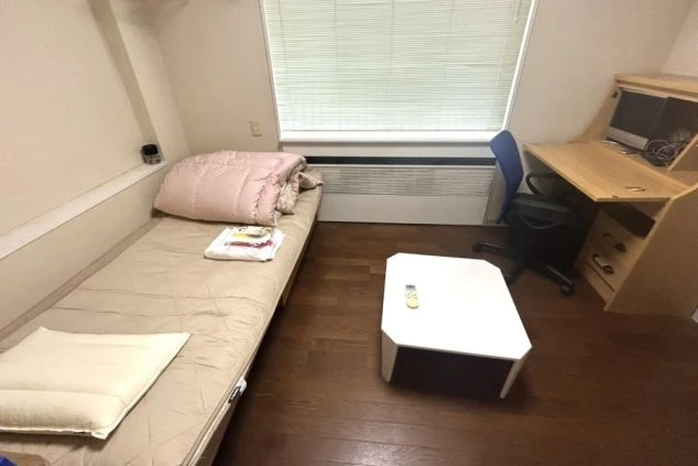 ベッド、机、椅子が備え付けられたリゾートバイト寮の個室の画像。