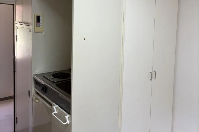 簡易なシンクと電熱コンロがある寮のミニキッチンの画像。