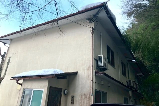 リゾートバイト住み込み求人の個室寮外観。雪景色に囲まれた落ち着いた環境にある、2階建てのスタッフ寮。