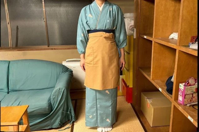 女性の制服。清潔感のある白い上着に紺色のゆったりとしたズボン。