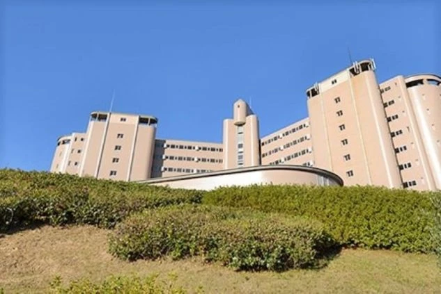 青空を背景に建つ、淡いピンク色のホテルの外観。