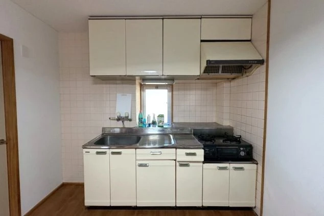 リゾートバイト寮のキッチン設備の画像。2口ガスコンロ、シンク、冷蔵庫、電子レンジ完備。