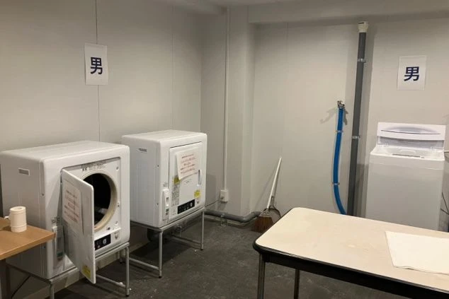 寮の洗濯室。洗濯機、乾燥機が並ぶ。