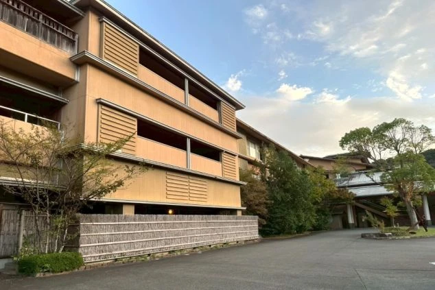 茶色を基調とした、落ち着いた雰囲気の旅館の外観。竹垣が和の趣を演出。